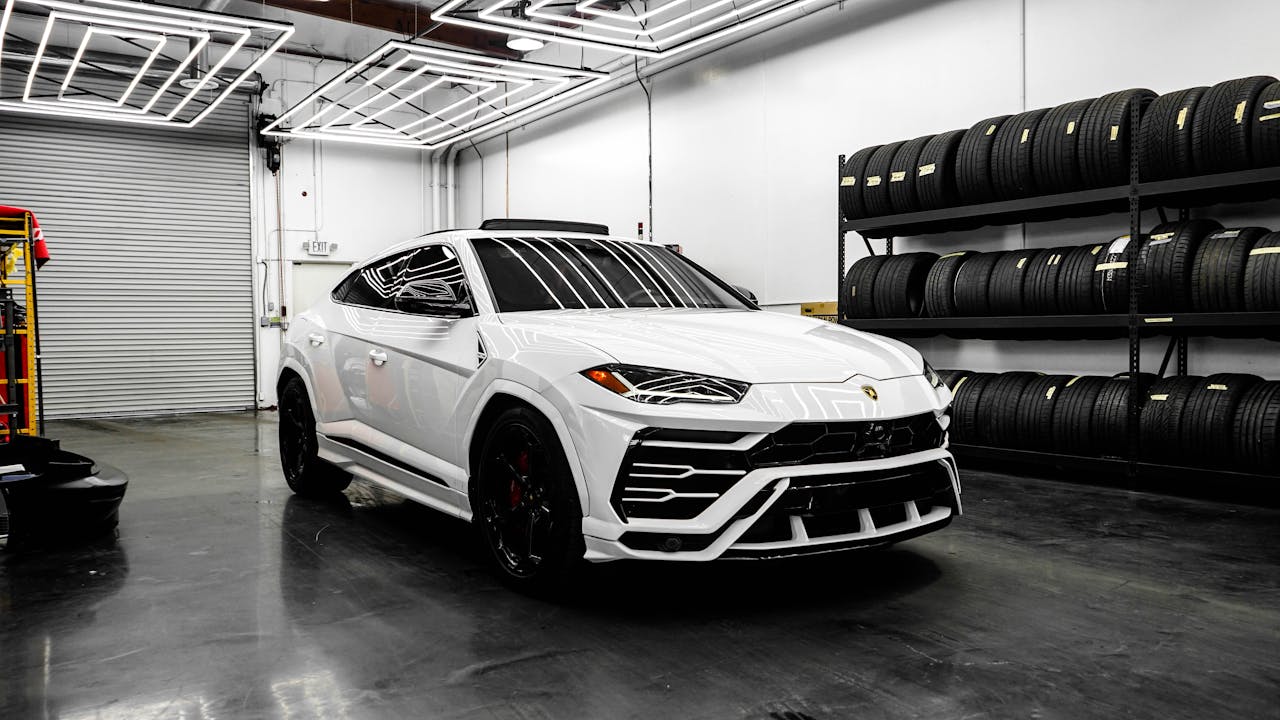 White Lamborghini Urus in garage showing Automotive Paint Protection Film (PPF) Pros and Cons at Infinite Auto Works auto protection shop in Charlotte and Concord, NC